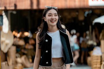 Happy young woman enjoying shopping in a street market in Asia