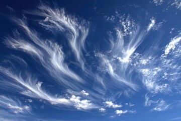Beautiful wispy clouds gracefully dancing across a bright blue sky during the day
