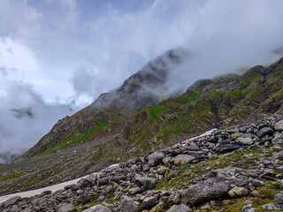Snow-Draped Highland Cliffside with Misty Peaks and Lush Green Valley
