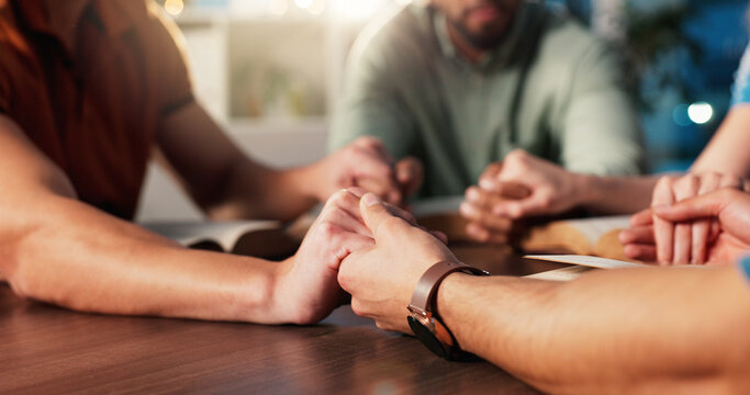 Bible, holding hands and prayer with people in home together for Christian belief, faith or religion. Book, community and spirituality with group of friends in apartment for learning or God worship