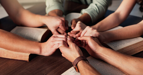 Bible, holding hands and religion with people in home together for Christian belief, faith or...