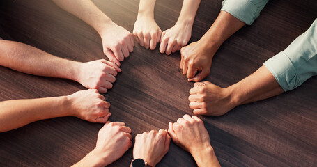 People, hands or circle with fist for team building, unity or mission together above. Top view,...