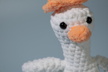 Crochet stuffed animal goose with a traffic cone on its head.