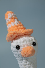 Crochet stuffed animal goose with a traffic cone on its head.