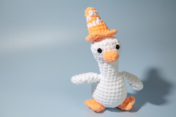 Crochet stuffed animal goose with a traffic cone on its head.