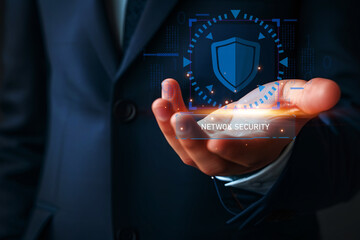 A man's hand holds a holographic representation of network security, symbolizing data protection. Cyber safety displayed as a futuristic concept of digital protection and risk management.