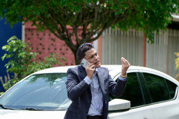 Man arguing on call outside the car. Angry male driver on call outside car