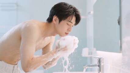 上半身裸で泡洗顔する男性のライフスタイル