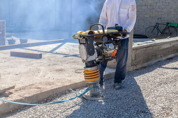 man operates a machine that is used to compact soil