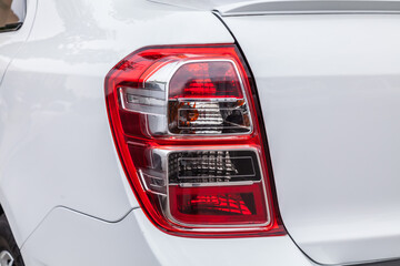 The back of a white car with a red tail light