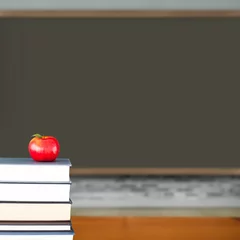 Fototapete Red apple on pile of books in classroom © vectorfusionart