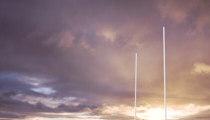 Flat design is showing slim white poles rising against sunset sky with golden lavender clouds