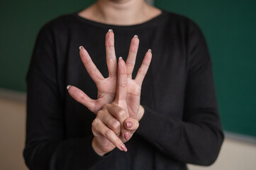 Woman shows the word standup in Russian sign language. 