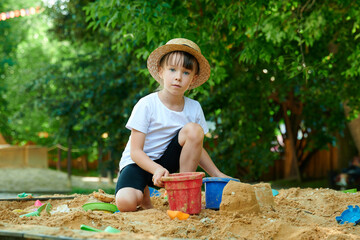 A six-year-old girl plays in a sandbox