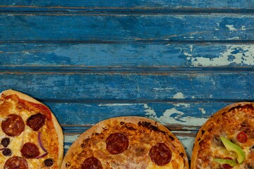 Fresh pizzas on blue weathered table