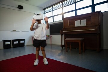 Low angel view of boy wearing virtual reality simulator gesturing