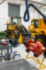 Two yellow machines parking in vector design workshop with red component, blue hoses, safety lines