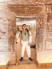 Tourist exploring ancient egyptian tomb with hieroglyphics