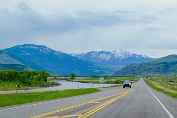 Scenic Highway Along River with Snowy Mountains in Montana