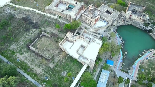 Aerial view of ancient ruins and pond surrounded by greenery, Pakistan.