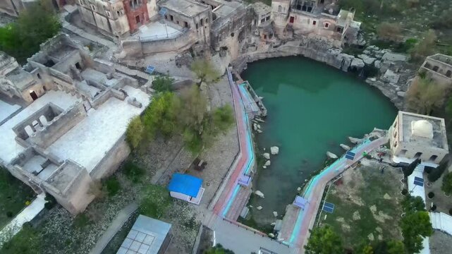 Aerial view of ancient temple ruins beside a pond, Pakistan.