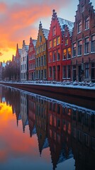 Obraz premium Colorful historic buildings reflected in calm canal water during a beautiful sunset image