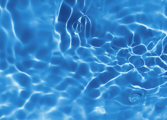 Abstract blurred shades of blue water background. Light and shadow ripples or splashes surface of water texture. Water waves and bubbles with shining and reflection pattern photography for​ artwork.