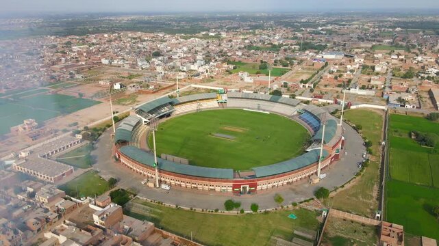 Aerial view of cricket stadium and cityscape, Pakistan.