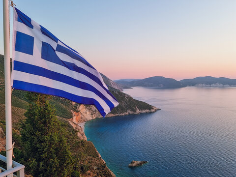 The Greek flag with the Gulf of Myrto(Kolpos Mirtou) in the background at sunset, the best panoramic view in Kefalonia, Kefalonia island, Greece