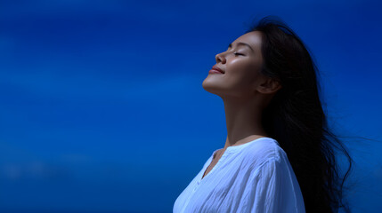 Serene Bliss: A radiant woman embraces the clear blue sky, her eyes closed, and a peaceful smile gracing her face. The soft light caresses her features, evoking a sense of serenity and contentment. 