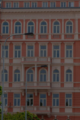 A large brick building designed with many windows, featuring an intricate facade and diverse architectural elements, stands prominently