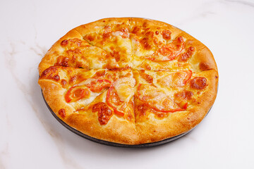 Freshly baked pizza with melted cheese and sliced tomatoes on display