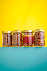 Colorful display of jars filled with granola against a bright background