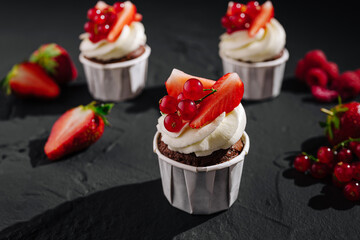 Delicious chocolate cupcakes topped with fresh strawberries and berries