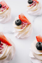 Delightful mini desserts topped with fresh berries and cream swirls