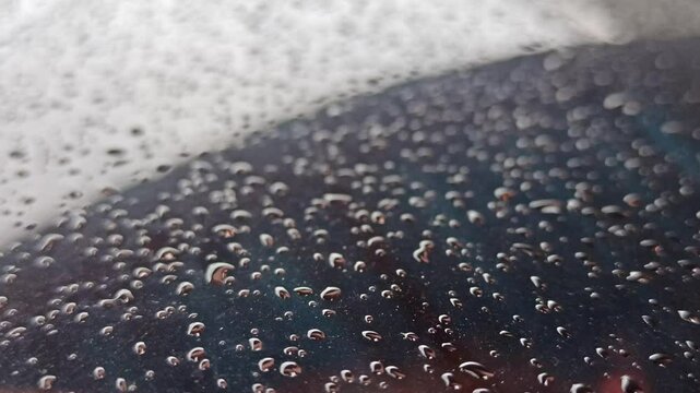 ight drizzle on a car window creates soft, wandering trails of water, blending movement and stillness in a calm, reflective driving moment