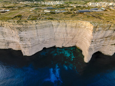 Aerial view of dramatic white cliffs plunging into the deep blue sea, a stunning contrast of textures and tones, Munxar, Munxar, Malta.