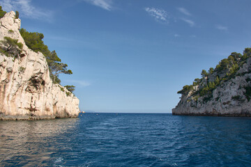 Boat trip through the Calanques of Marseille with blue waters and rock formations under a clear Mediterranean sky