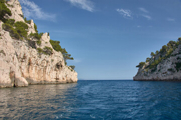 Boat trip through the Calanques of Marseille with blue waters and rock formations under a clear Mediterranean sky