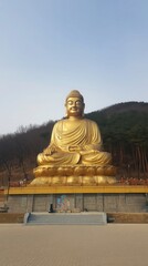 Golden Serenity: Majestic Golden Statue Amidst Tranquil Landscape and Spiritual Monument
