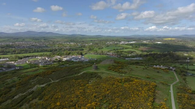 Vinegar Hill, Enniscorthy, County Wexford, Ireland, April 2025. Drone establishing panoramic overview orbits counter clockwise with monument at center and view of distant town behind on cloudy day.