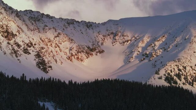 East Wall Chute sunset Arapahoe Basin Basin Abay Ski Resort Colorado aerial drone Loveland Pass winter spring last light golden hour groomed ski trail runs main lodge Base Area circle left motion