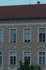 There is a large and impressive building that features numerous windows and boasts a striking red roof that catches the eye