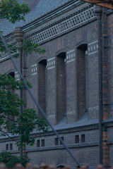 A small group of individuals is gathered together in front of a large, impressive brick building...