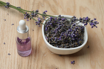 Bottles with lavender oil, lavender on wooden background