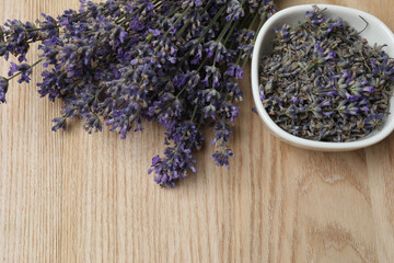 Bottles with lavender oil, lavender on wooden background
