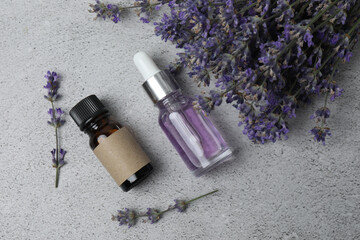 Bottles of lavender oil, lavender on marble background