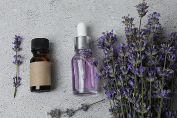 Bottles of lavender oil, lavender on marble background
