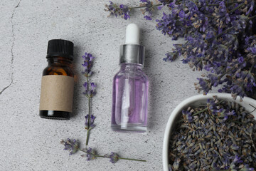 Bottles of lavender oil, lavender on marble background