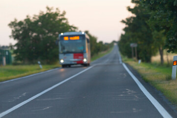 A large bus is steadily driving along a scenic country road that showcases beautiful landscapes and...